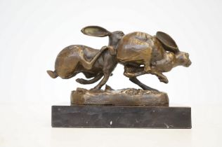 Bronze running hares on marble base signed