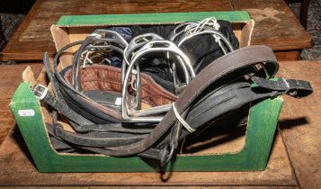 Three sets of stirrups, a girth, two bits, two hat covers and leather pieces