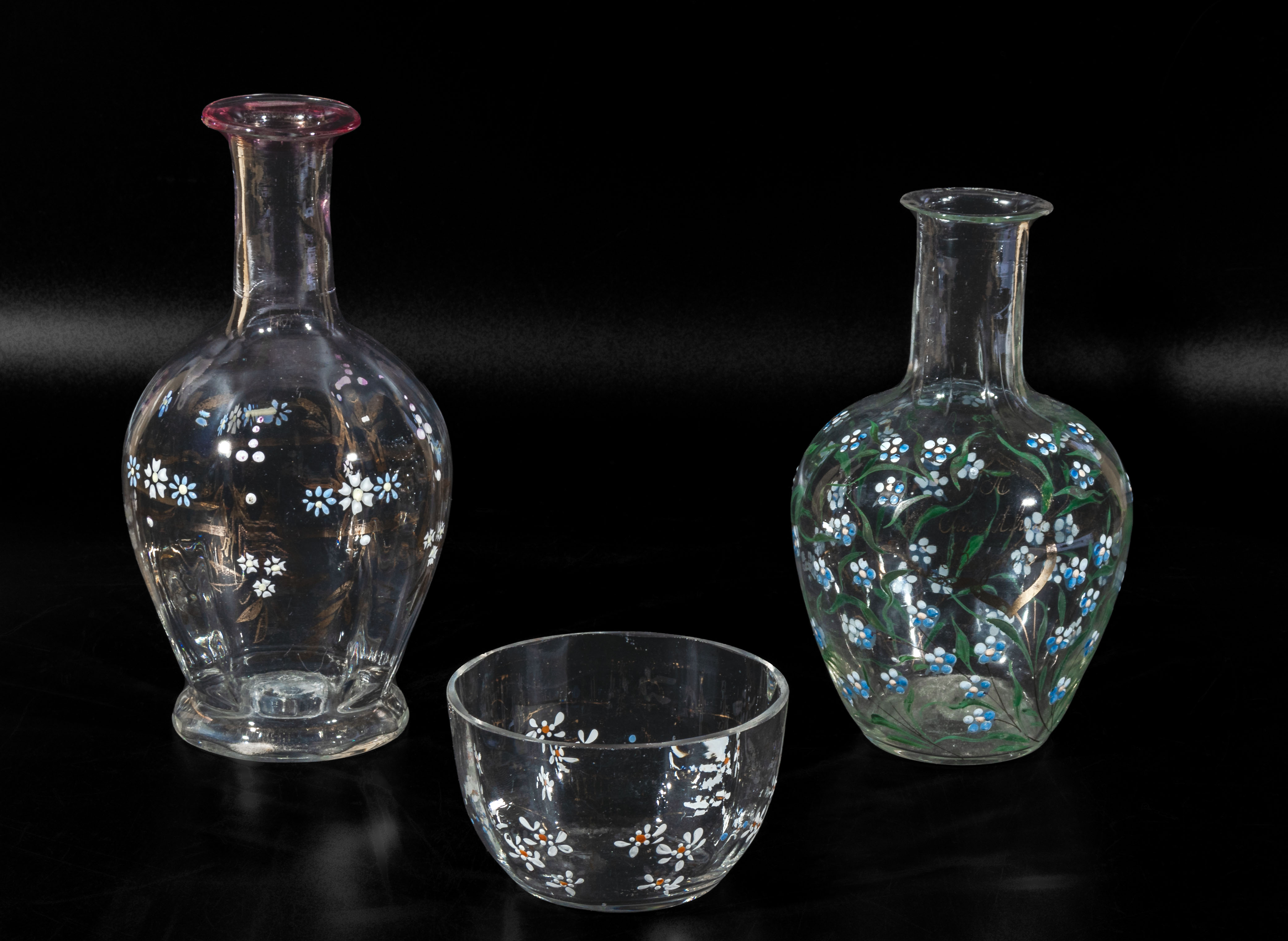 Two decorated glass carafes and a bowl