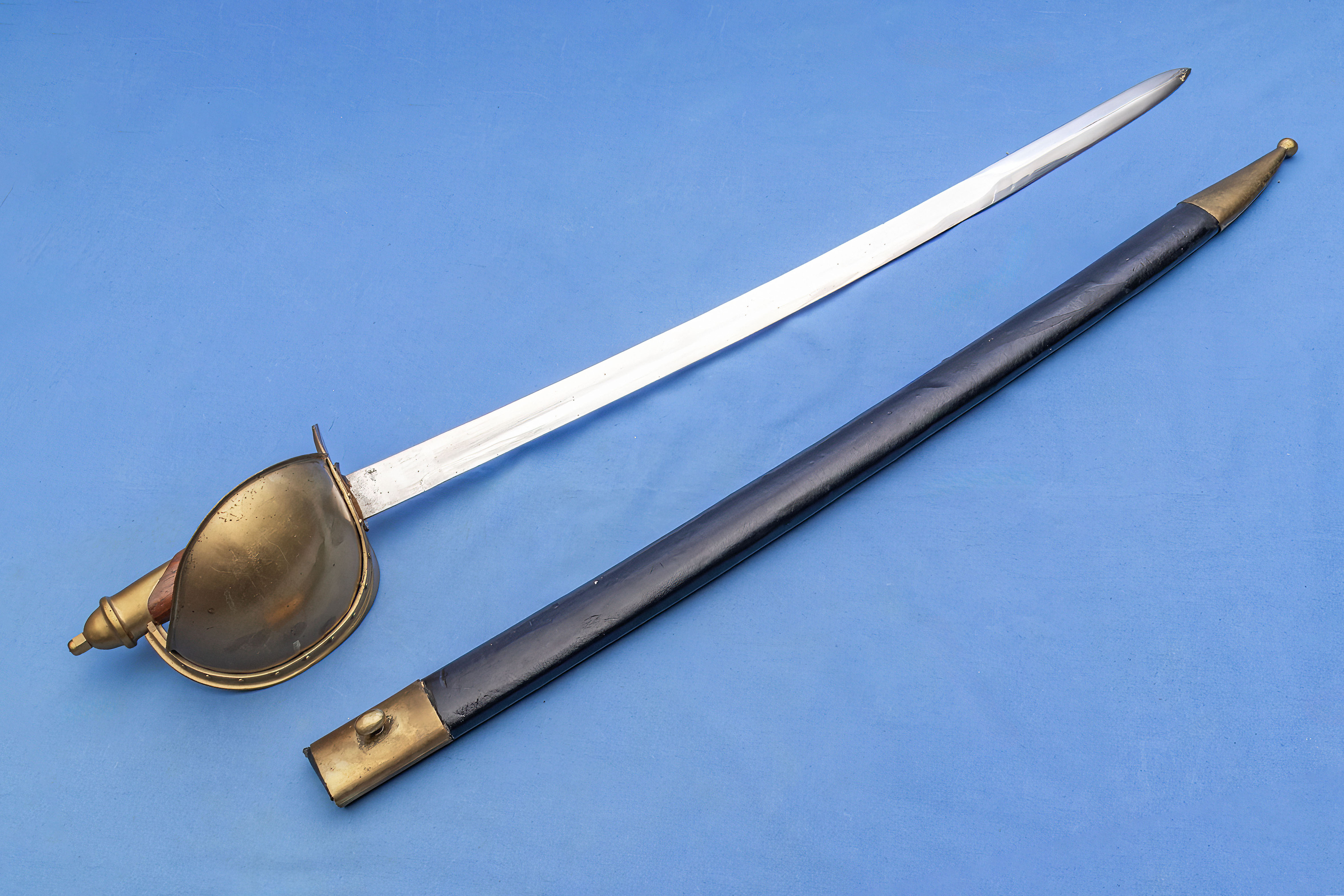A replica Naval cutlass with black leather scabbard
