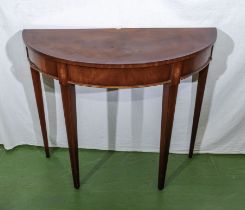 A mahogany demi lune table with shell inlay