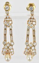 A pair of elegant diamond and pearl drop yellow metal earrings, the pearl set to the bottom of a