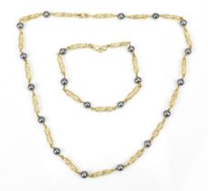 A 14ct yellow gold and pearl parure set of a necklace and bracelet, designed with pierced links