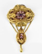 A Victorian Etruscan revival yellow metal and amethyst brooch, with central floral cluster, the