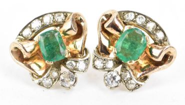 A pair of emerald and diamond yellow and white metal earrings, each set with a central emerald in