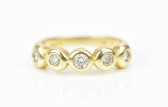 A 14 ct yellow gold and diamond five stone ring, set with five bezel set graduated brilliant cut