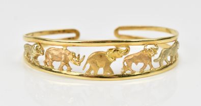 An 18ct yellow gold bangle designed with safari animals in a pierced mount, stamped 750, 6.2 cm