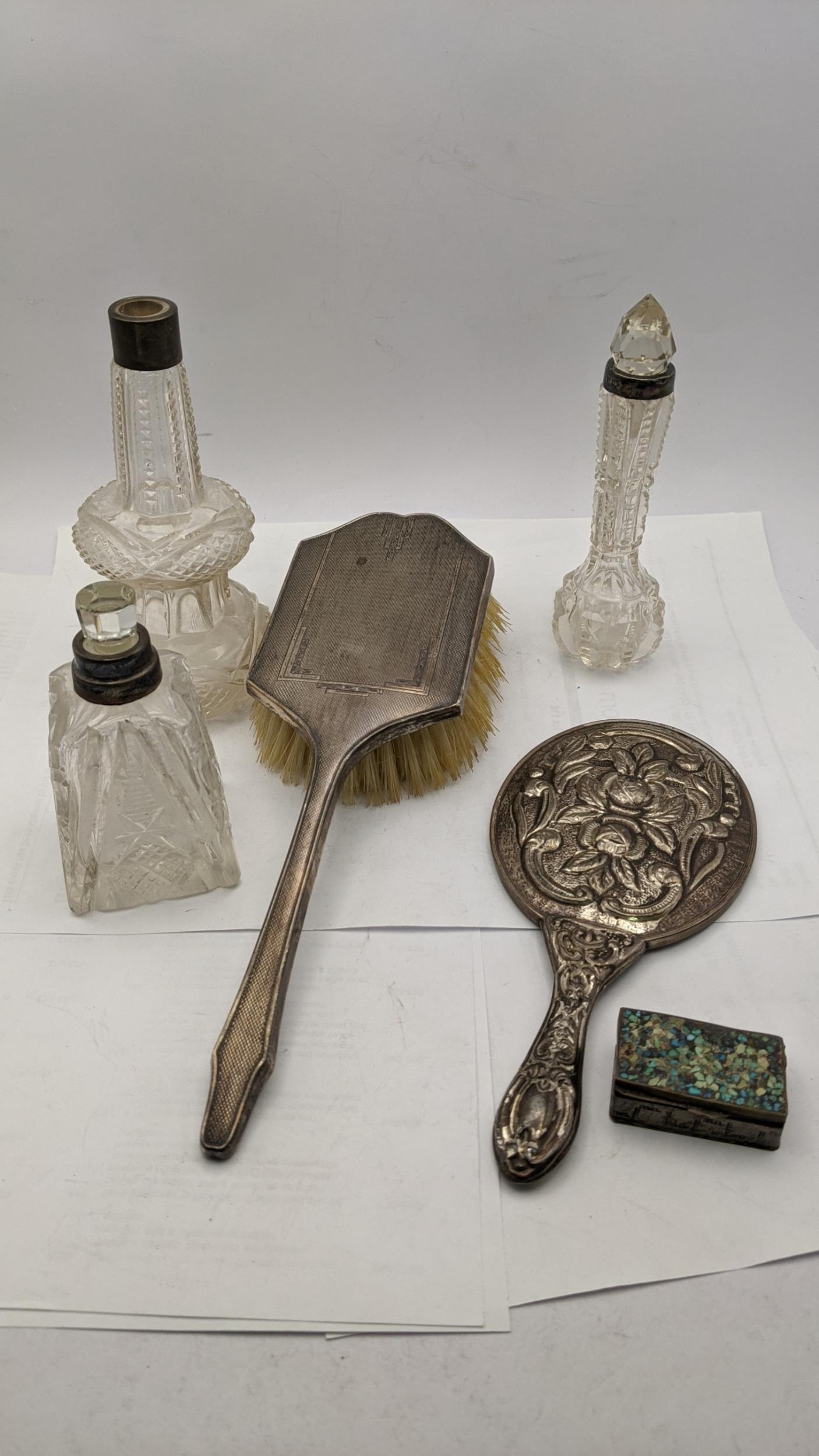 Silver and white metal dressing table items to include a hair brush, an embossed mirror stamped 900,