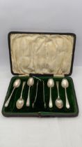 A cased set of silver spoons along with a pair of sugar thongs having a floral engraved design total