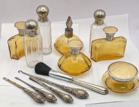 Dressing table items to include brown glass bottles with engine turned lids, silver handled manicure