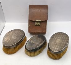 Three silver dressing table brushes to include a pair having engine engraved detail and one in a