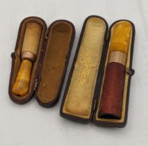 A Cheroot holder A/F having an amber coloured mouth piece and a 9ct gold band, together with a cigar