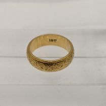 A 18ct gold wedding band having engraved floral details 5.7g Location: