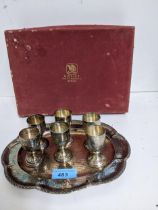 A white metal set of six liqueur goblets on a shaped oval tray, hammered decoration, stamped marks R