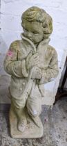 A weathered garden concrete statue of a man in a winter coat standing on a square garden concrete