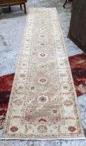A Persian hand woven runner, decorated with flower heads on a beige ground, triple guard borders,