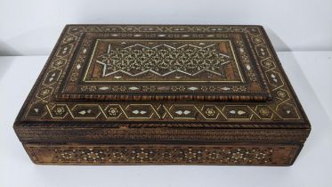 An early 20th century Middle Eastern marquetry inlaid box having repeating motifs, mother of pearl