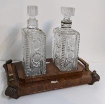 An Art Deco walnut veneered tantalus with two crystal cut decanters, 30h x 37w A/F Location: