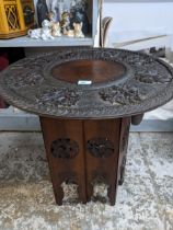 An early 20th century carved hardwood table of a folding octagonal base Location: