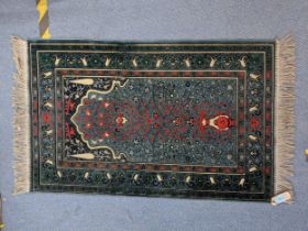 A Turkish rug with multicoloured symmetrical decoration on a dark blue background 67cm 119cm