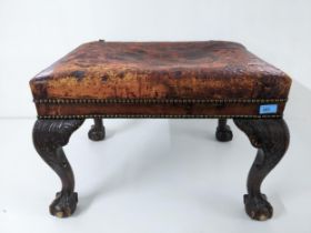 Late Victorian/early 20th century carved mahogany stool, faded red upholstered set, on leap carved