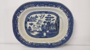 An early 19th century pearlware Old Willow pattern meat plate with gravy well, 57.5cm Location: