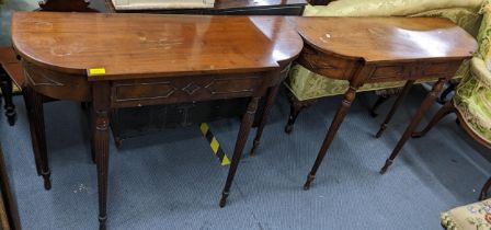 A pair of 1920s mahogany Regency inspired hall tables having single drawers and tapering reeded legs