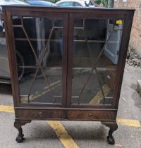 A mahogany display cabinet with twin astragal doors, internal shelves, over two base drawers, on