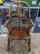 An early 20th century Windsor comb back armchair, crinoline stretcher, on ring turned legs