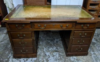 An early 20th century mahogany twin pedestal writing desk the top with inset green tooled leather