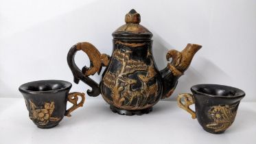 A Chinse soapstone relief carved teapot and two matching tea bowls Location: