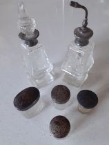 A group of 6 early 20th Century mixed glass dressing table bottles and pots having silver or white