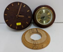 Two modern clocks and a wooden clock surround Location: