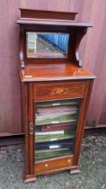 An Edwardian mahogany music cabinet having a raised mirrored back and single glazed door, 126cm h