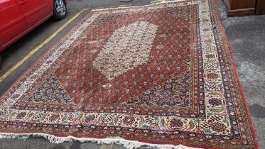 A Persian handwoven carpet having a red ground with a central motif and geometric design 434x331 (