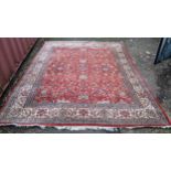 Persian hand woven rug having a red ground with a floral design multiguard borders and tasselled