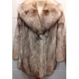 A late 20th Century arctic fox fur coat with brown shades having a shawl collar, grey satin lining