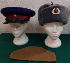 A collection of 3 Russian service hats to include a mid 20th Century USSR NKVD Officer's peaked