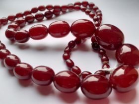 A cherry amber necklace comprising graduating beads, total length 81cm. Location: CAB2