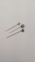 Three yellow metal stick pins to include a cameo stick pin, total weight 4.9g Location: