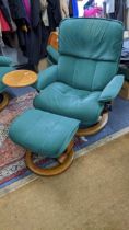 A Stressless Ekornes green fabric upholstered reclining armchair with a table and stool Location: