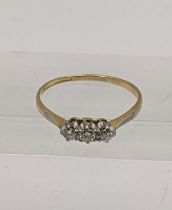 A yellow metal and three stone diamond ring 1.7g Location: