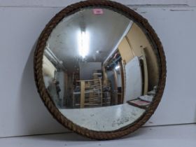 An early 20th century convex circular wall mirror with rope twist frame, etched marks around