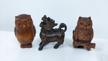 Three Chinese carved wooden netsukes, two owls and a dog of fo Location: