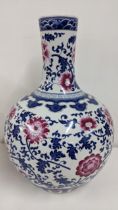 A large modern Chinese blue and white bulbous vase having a floral design with pink flowers, 52.