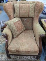 A Victorian style mahogany framed wingback armchair having scrolled arms and bulbous feet Location: