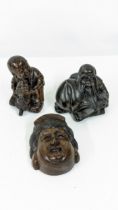 Three Chinese carved wooden netsukes, a mask, a boy with a dog, and an elderly man Location: