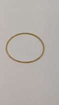 A 22ct gold bangle having engraved textured design 7.6g Location: