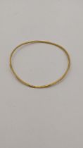 A 22ct gold bangle having engraved textured design 7.3g Location