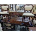 A reproduction mahogany extending dining table on turned and fluted tapering legs and casters,